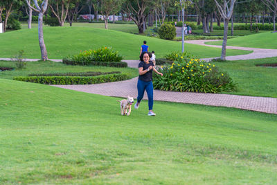 Rear view of boy running on grassy field