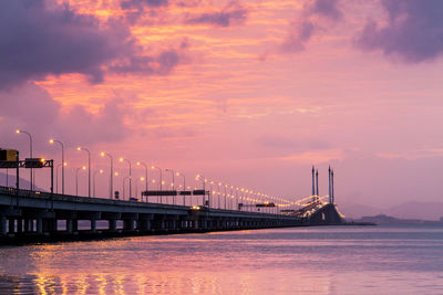 Bridge over river against sky during sunset