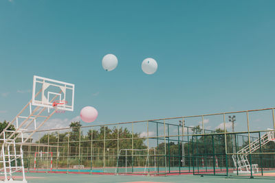 Low angle view of balloons against blue sky