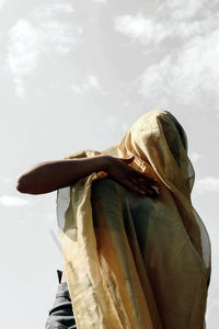 Low angle view of woman standing against sky