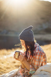 Young woman drinking coffee outdoors