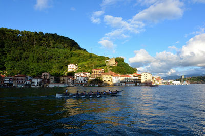 Buildings by sea against sky