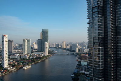 River amidst buildings in city against sky