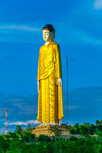 Statue of cross against blue sky