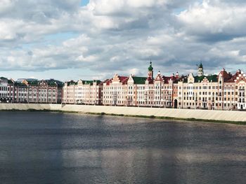 River by buildings against sky in city