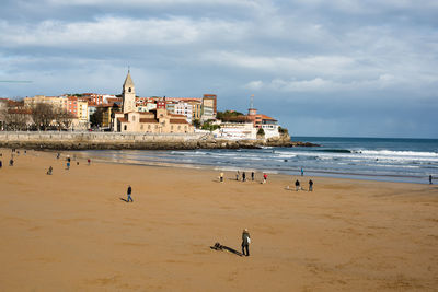 View of buildings on beach against cloudy sky