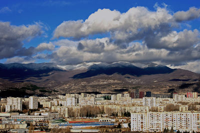 View of cityscape against cloudy sky