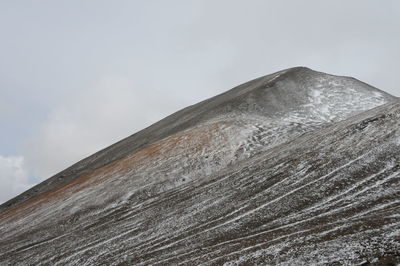 Low angle view of volcanic mountain against sky