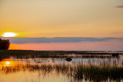 Scenic view of lake against romantic sky at sunset