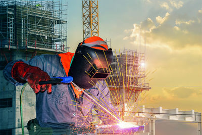 Man working at construction site against sky