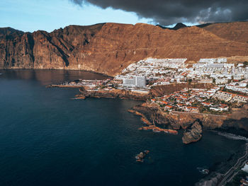 High angle view of townscape by sea against sky