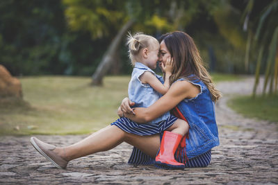 Mother and girl with arms raised