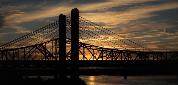 Silhouette bridge against sky at sunset