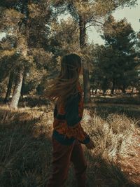 Woman standing by tree on field