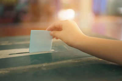 Close-up of hand holding text on table