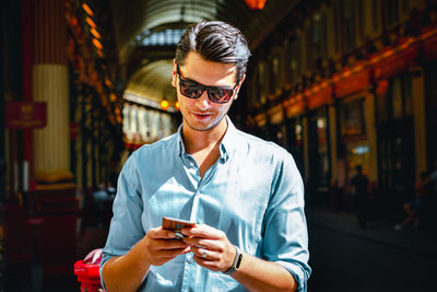 Portrait of young man wearing sunglasses standing outdoors