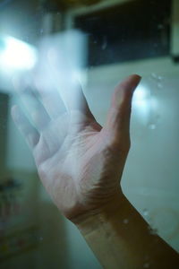 Close-up of person hand on glass window