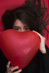 Portrait of woman holding red heart
