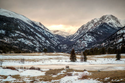 Snowcapped landscape against sky during sunset