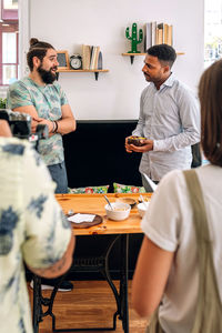 Multi-ethnic friends talking by table
