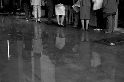 Low section of people standing on tiled floor