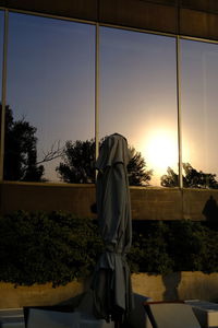 Low section of woman standing on railing against sky