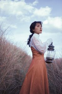 Woman standing on field against sky