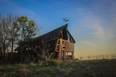 Abandoned house on field against sky