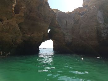 Rock formation in sea against sky