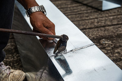 Low angle view of man working on metal