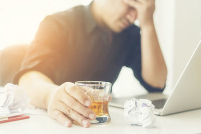 Businessman with having drink at desk in office