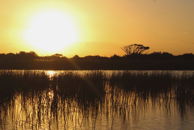 Scenic view of lake against sky during sunset