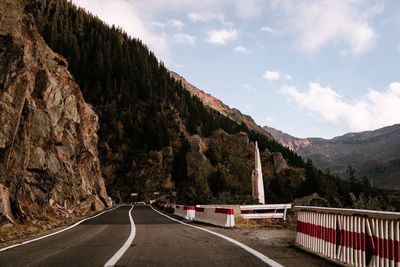 Road by mountain against sky