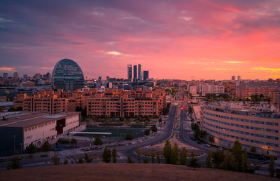 Wonderful vivid sunset over residential buildings and skyscrapers in modern city of madrid