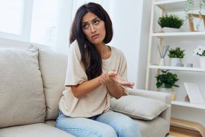 Portrait of young woman sitting on sofa at home