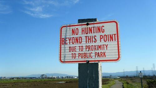 Warning sign against blue sky