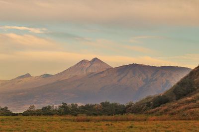 Scenic view of mountain range against cloudy sky