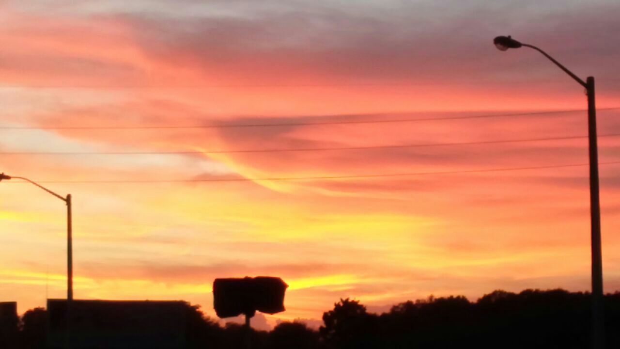 sunset, silhouette, sky, orange color, street light, cloud - sky, beauty in nature, low angle view, scenics, tranquility, tranquil scene, nature, dramatic sky, lighting equipment, idyllic, cloud, cloudy, moody sky, tree, dusk