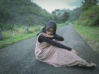 Portrait of young woman on road