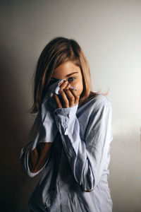 Portrait of girl standing against wall