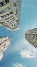 Low angle view of buildings against cloudy sky