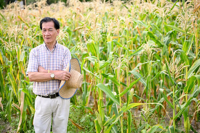 Portrait of young man standing amidst plants