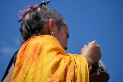 Low angle view of man against clear blue sky