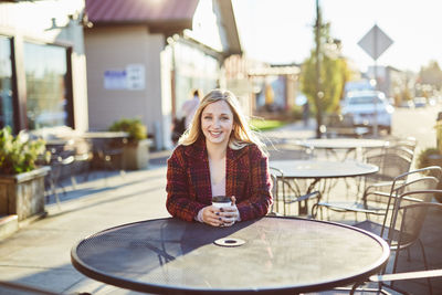 Young woman sitting at sidewalk cafe