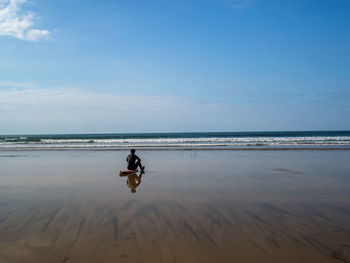 Surfer sat on the shoreline 