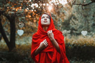 Young woman standing on cross in forest