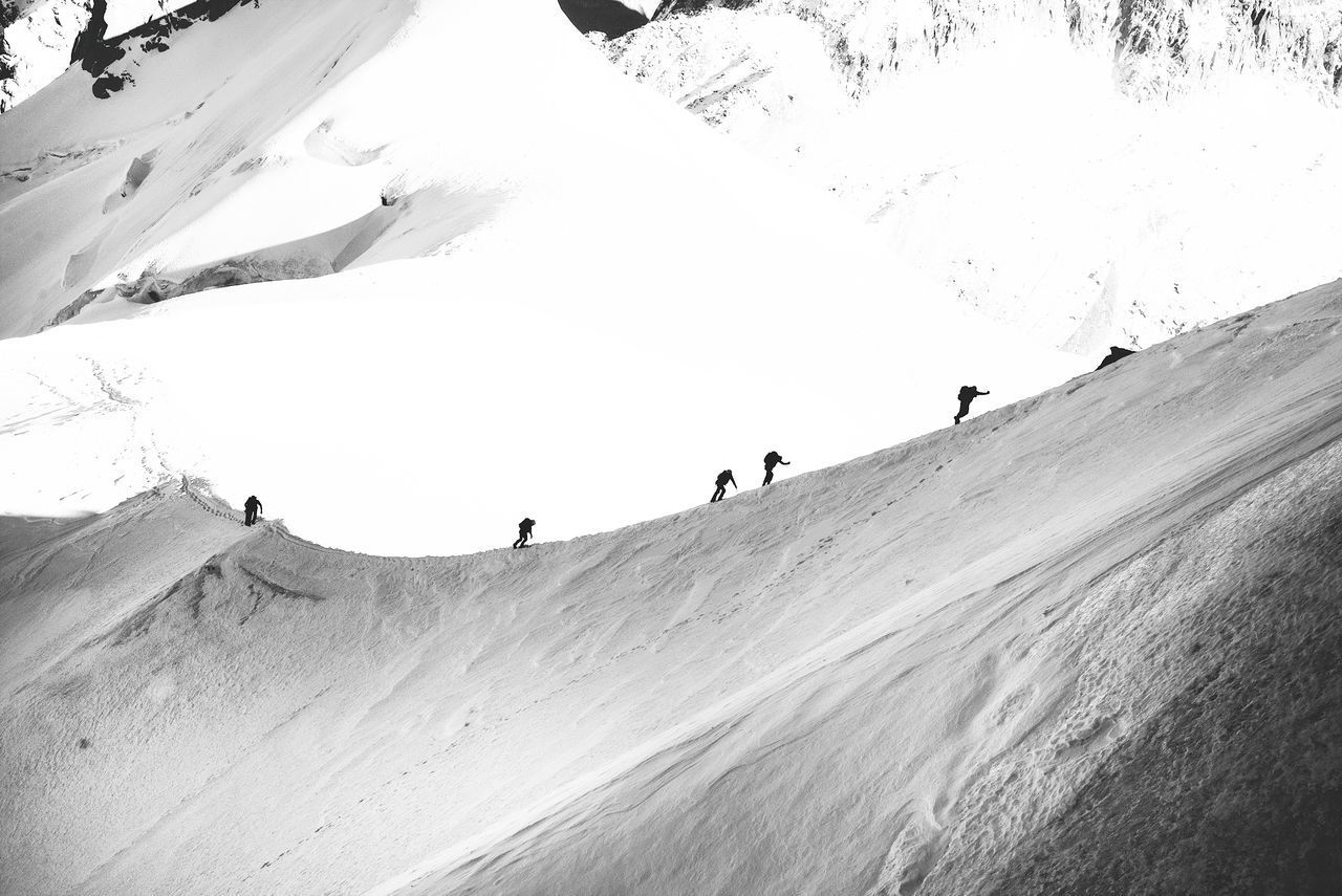 GROUP OF PEOPLE ON SNOWCAPPED MOUNTAIN AGAINST SKY