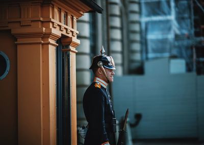 Man standing by window of building