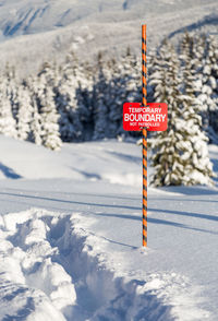 Road sign on snow covered field