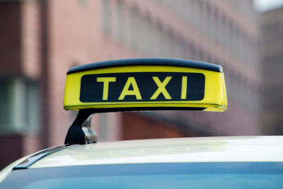 Close-up of taxi sign against building